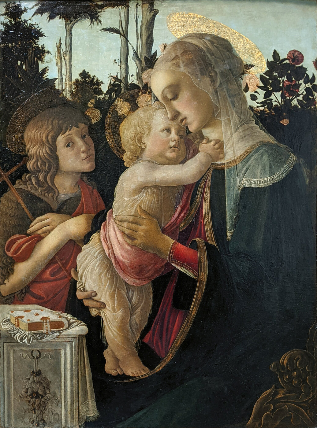 Botticelli's Louvre Madonna, the Virgin's head lowered over the Child, the young St John at left